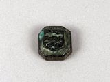 gros plan d'un petit objet métallique sur une surface blanche