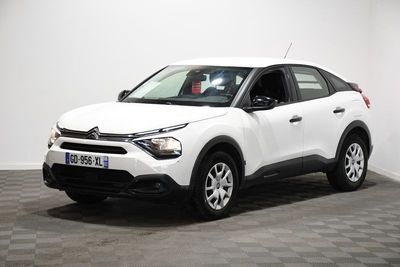 La voiture blanche est garée dans une pièce dont le sol est en damier.