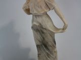 statue en marbre représentant une femme tenant un chat, posée sur un socle