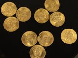 a close up of a bunch of gold coins on a black surface