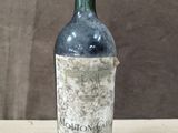 une vieille bouteille de vin posée sur une table en bois