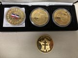 three gold coins in a black box with a cross and a medal