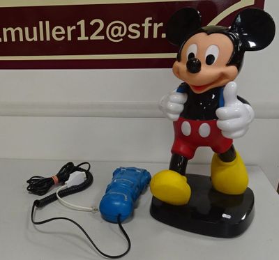 une figurine de Mickey Mouse posée à côté d'un plat de service sur une table