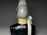 a black and white vase with a white ribbon on it