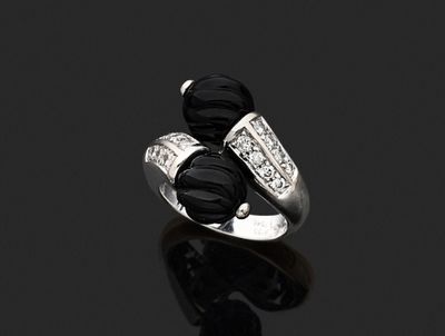 un gros plan d'une bague sertie d'un diamant noir et blanc sur une surface noire