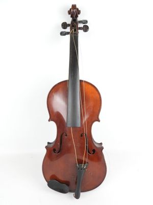 un vieux violon posé sur un pupitre en bois, lui-même posé sur une surface blanche