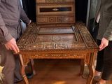 a man and a woman standing next to a wooden table