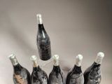 six bottles of wine sitting in a bucket on a table