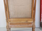 a wooden chair with a wicker back in a room