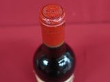 a bottle of wine sitting on a red surface