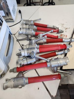 un tas de lances à incendie rouges et argentées posées sur une table