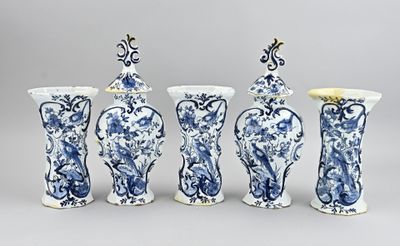 quatre vases bleus et blancs sont alignés sur un fond gris