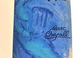 un vieux livre à la couverture bleue, sur laquelle est dessiné le visage d'un homme