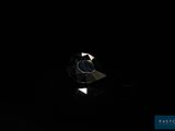 un gros plan d'un diamant posé sur une surface noire dans l'obscurité