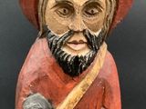 wooden figurine of a man with a red hat and beard holding a hammer