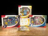 three boxes of pokemon toys sitting on top of a wooden table