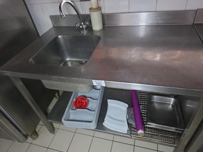 un évier en acier inoxydable dans une cuisine équipée d'un égouttoir à vaisselle
