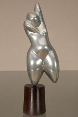 sculpture représentant le torse d'une femme, posée sur un socle en bois, elle-même posé sur une table