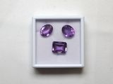 des améthystes violettes dans une boîte blanche posée sur une surface blanche