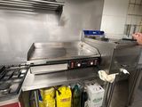 a man that is standing in a kitchen preparing food
