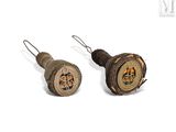 pair of antique wooden buttons with a design on them on a white background