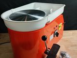 une machine orange et blanche posée sur une table en bois