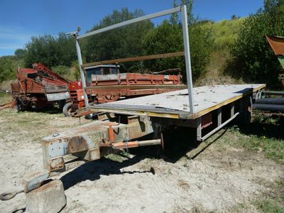 un camion à plateau garé sur un terrain en terre battue