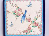 un oiseau bleu perché sur une assiette bleue et blanche