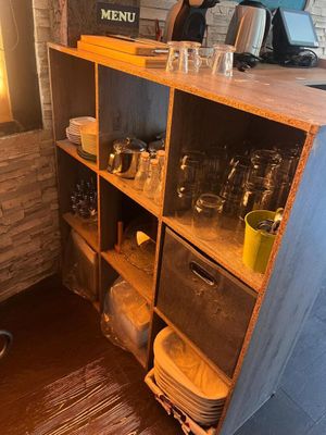 une étagère sur laquelle sont posés de la vaisselle et des verres, dans la cuisine