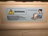 a warning sign on the back of a washing machine