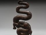 un gros plan d'une sculpture représentant un serpent posé sur une boule