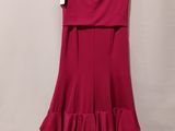 a red dress hanging on a hanger against a wall