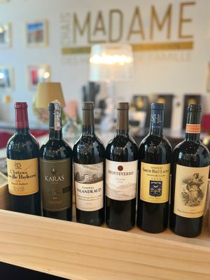 many bottles of wine sitting on a wooden tray