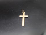 a small gold cross on a black surface