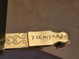 a gold knife with writing on it on a table