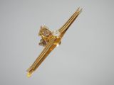 a gold plated chopstick with a diamond on it