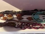 a lot of necklaces and bracelets sitting on a shelf