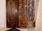 un grand vase en verre posé sur une table, à côté d'une petite boîte en bois
