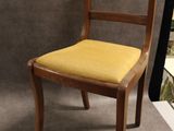 une chaise en bois avec une assise jaune sur fond gris