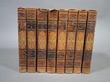 six vieux livres sont empilés sur une table