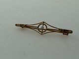 a picture of a gold hair clip on a white surface