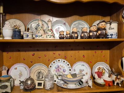 une étagère en bois sur laquelle sont disposées de nombreuses assiettes de différents types