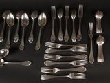 many forks and spoons laid out on a table