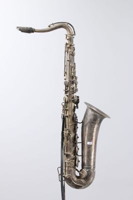 an old silver saxophone on a stand against a white background