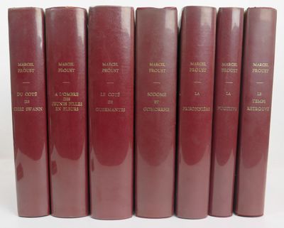 six livres rouges alignés sur une surface blanche