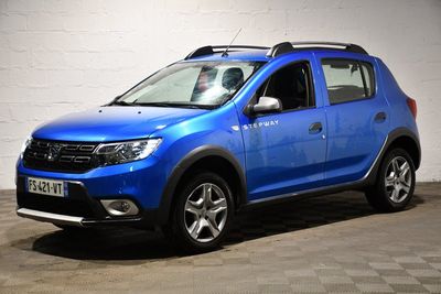 La Dacia bleue est garée dans le garage, avec sa galerie de toit.