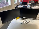 two monitors sitting on a desk in an office