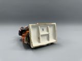 a small white plate with a letter h on it