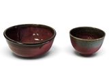 pair of red and black bowls on a white background