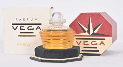 un petit flacon de parfum posé à côté d'une boîte